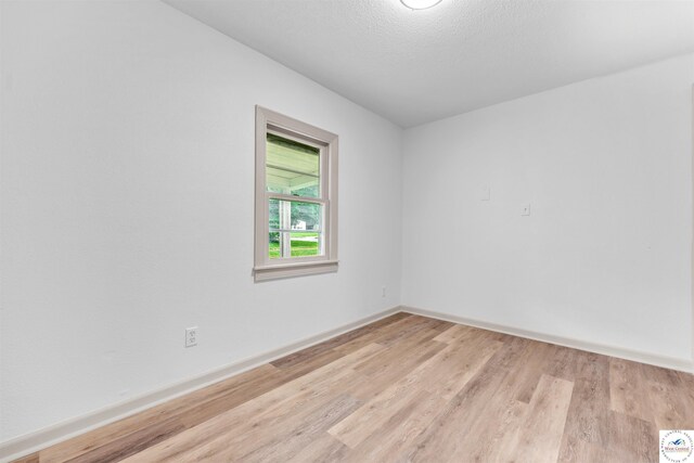 1803 S Quincy Ave, Sedalia, MO 65301 - unfurnished room with light wood-style floors, baseboards, and a textured ceiling