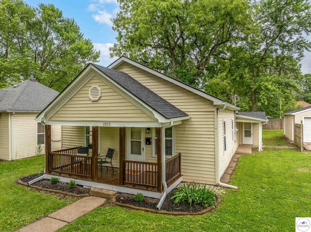 1803 S Quincy Ave, Sedalia, MO 65301 - view of front of property with covered porch, a front yard, and a shingled roof