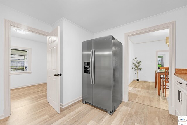1803 S Quincy Ave, Sedalia, MO 65301 - kitchen featuring stainless steel refrigerator with ice dispenser, light wood finished floors, baseboards, white cabinetry, and ornamental molding
