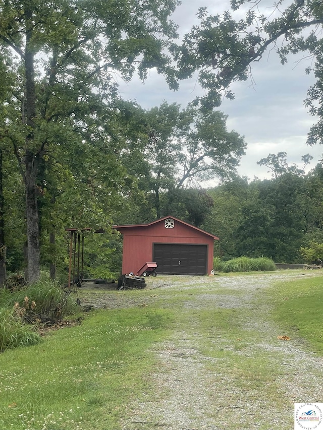 791 SE 1211th Rd, Deepwater, MO 64740 - view of green lawn featuring a detached garage, an outdoor structure, and a wooded view