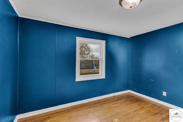 6204 E 147th Ter, Grandview, MO 64030 - spare room featuring wood finished floors, a textured ceiling, and baseboards