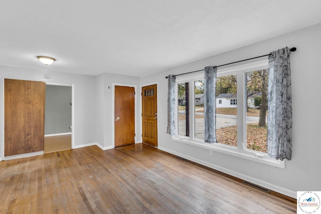 6204 E 147th Ter, Grandview, MO 64030 - spare room with baseboards, wood finished floors, and a textured ceiling