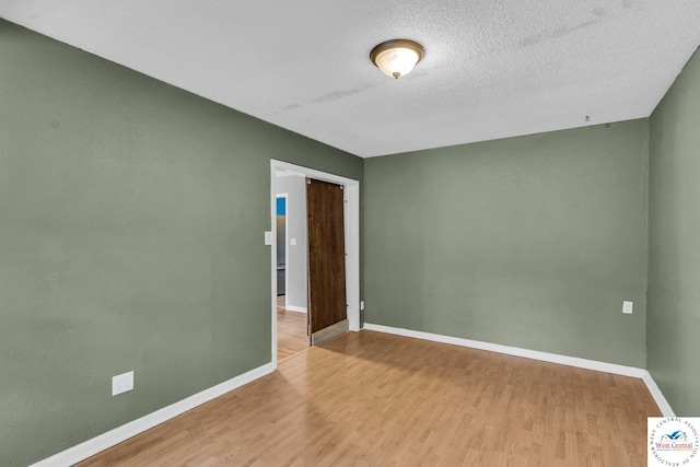 6204 E 147th Ter, Grandview, MO 64030 - spare room with wood finished floors, baseboards, and a textured ceiling