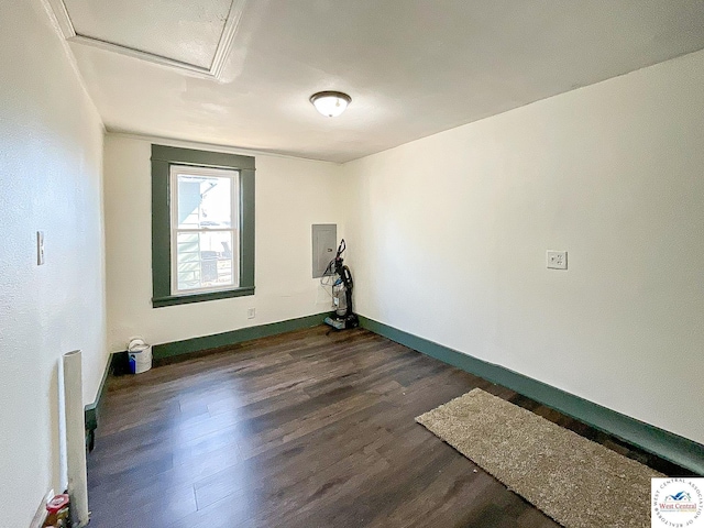 empty room with baseboards, attic access, and dark wood-type flooring