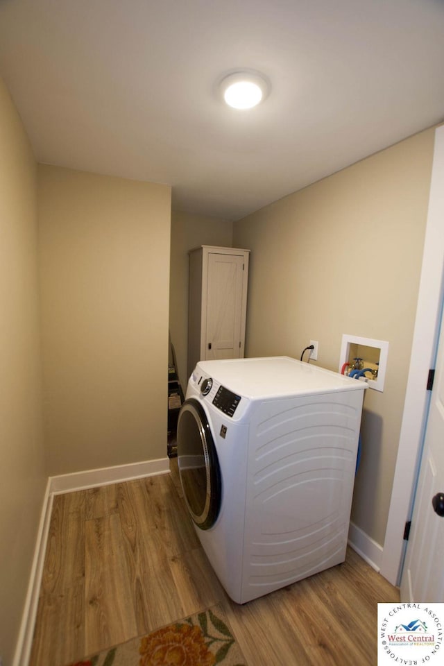 1625 W 16th St, Sedalia, MO 65301 - washroom with washer / dryer, light wood-style floors, baseboards, and cabinet space