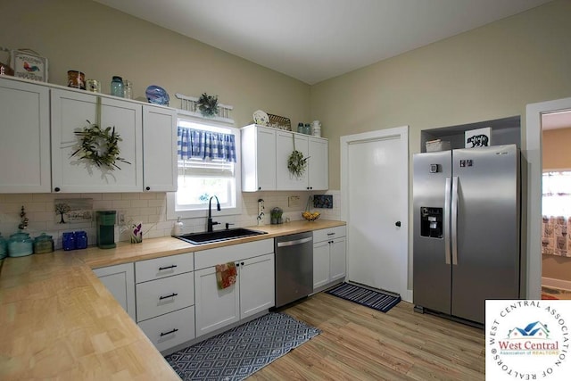 1625 W 16th St, Sedalia, MO 65301 - kitchen featuring appliances with stainless steel finishes, a sink, tasteful backsplash, wooden counters, and white cabinets