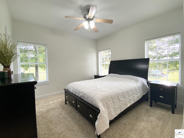 bedroom with baseboards, a ceiling fan, and light carpet