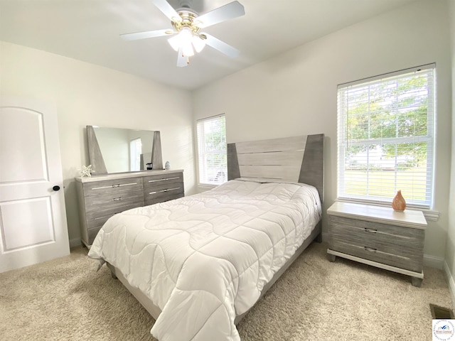 bedroom with light carpet, baseboards, and ceiling fan