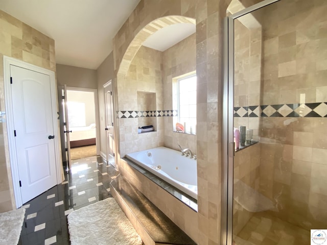 bathroom featuring tile walls, a stall shower, and a whirlpool tub