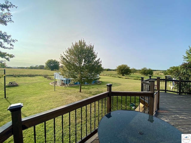 wooden terrace featuring a yard and a rural view