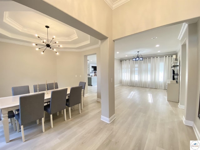 dining room with an inviting chandelier, light wood-style floors, and crown molding
