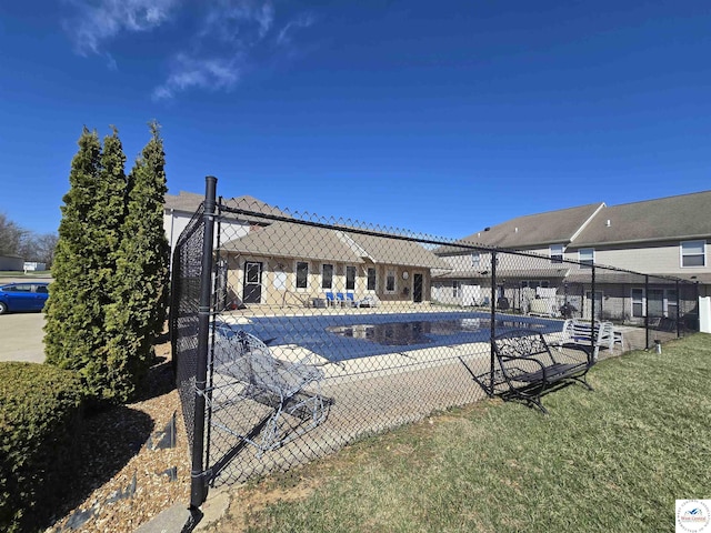 pool with a patio, fence, and a yard
