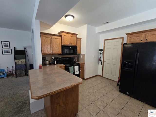 kitchen with black appliances, brown cabinets, backsplash, and a peninsula