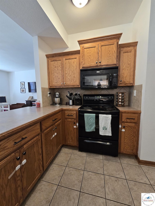 kitchen featuring black appliances, tasteful backsplash, and light countertops