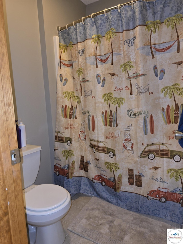 bathroom featuring toilet, tile patterned flooring, and a shower with shower curtain