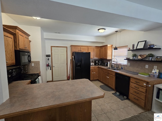 kitchen with decorative light fixtures, black appliances, backsplash, a sink, and a peninsula
