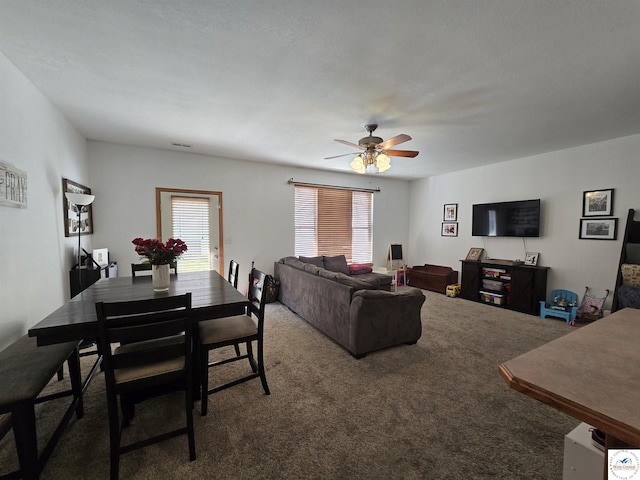 carpeted living area featuring visible vents and a ceiling fan