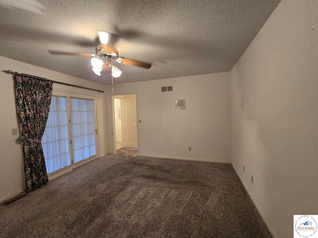 carpeted empty room featuring a ceiling fan, visible vents, a textured ceiling, and baseboards