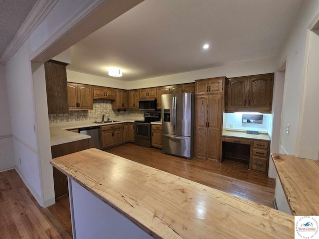 kitchen with tasteful backsplash, appliances with stainless steel finishes, wooden counters, a sink, and dark wood-style floors