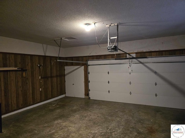 garage featuring wood walls and a garage door opener
