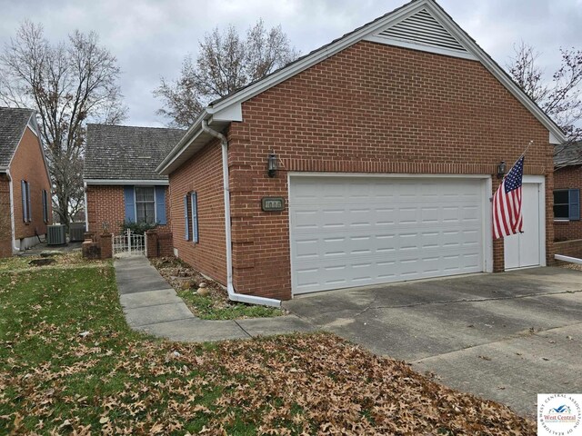 1006 E Palmer Pl, Clinton, MO 64735 - view of side of property featuring a garage, brick siding, and cooling unit
