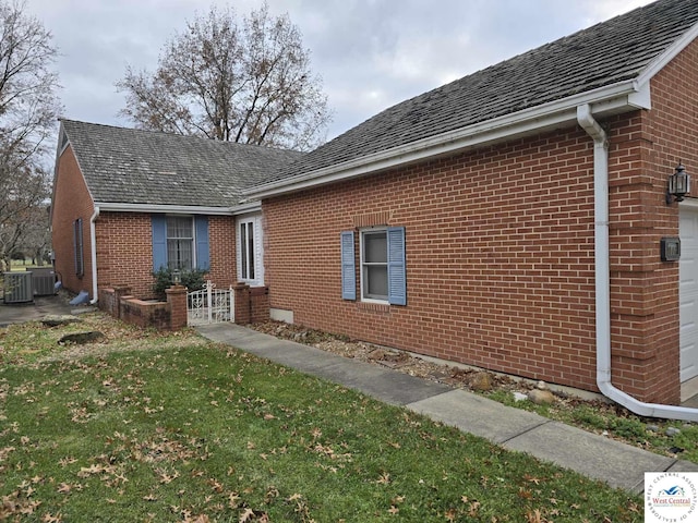 view of home's exterior featuring a yard, central AC unit, and brick siding