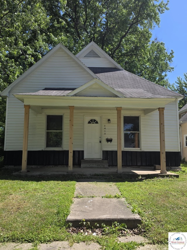 1413 W 11th St, Sedalia, MO 65301 - view of front of home featuring covered porch, a front yard, and roof with shingles