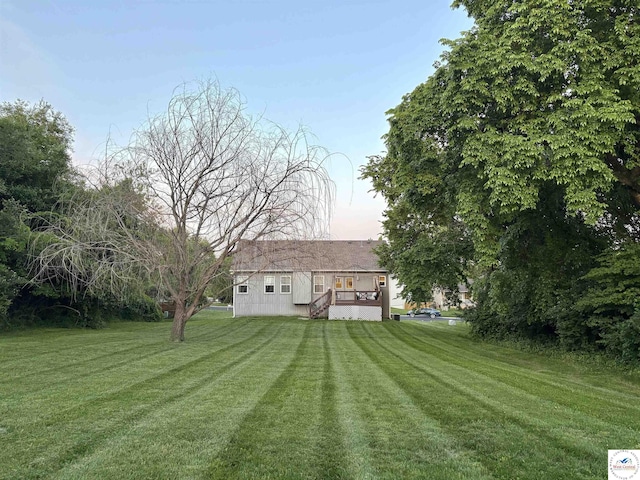 back of property featuring a lawn and a deck
