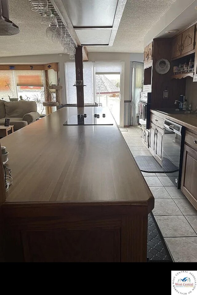592 Woodland Dr, Climax Springs, MO 65324 - kitchen featuring appliances with stainless steel finishes, a textured ceiling, light tile patterned floors, and a sink
