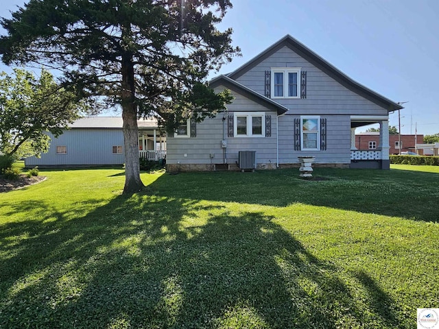 406 W Main St, Cole Camp, MO 65325 - rear view of property featuring a yard and covered porch