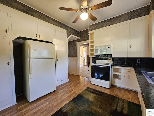 406 W Main St, Cole Camp, MO 65325 - kitchen featuring white appliances, wood finished floors, ceiling fan, white cabinetry, and wainscoting