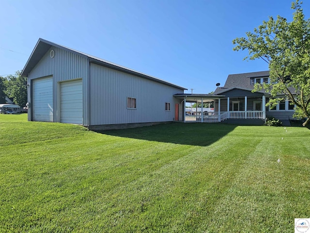 406 W Main St, Cole Camp, MO 65325 - rear view of property featuring a detached garage, an outbuilding, and a lawn