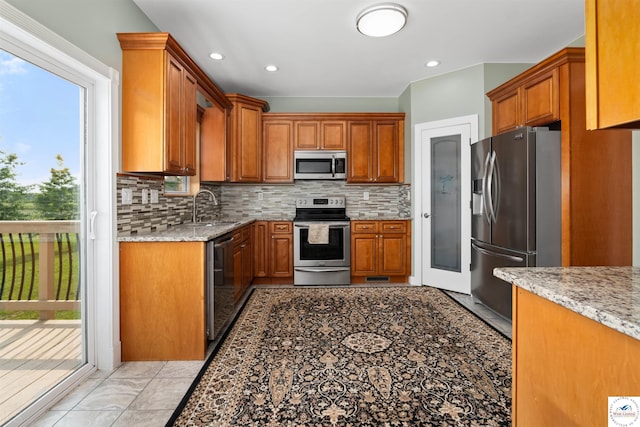 29854 Griessen Rd, Smithton, MO 65350 - kitchen with stainless steel appliances, a sink, tasteful backsplash, light stone counters, and recessed lighting