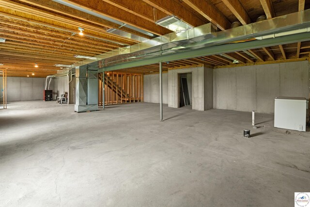 29854 Griessen Rd, Smithton, MO 65350 - unfinished basement with stairway, refrigerator, and heating unit