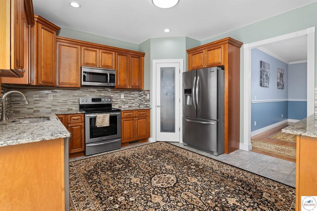 29854 Griessen Rd, Smithton, MO 65350 - kitchen with stainless steel appliances, a sink, decorative backsplash, light stone counters, and crown molding
