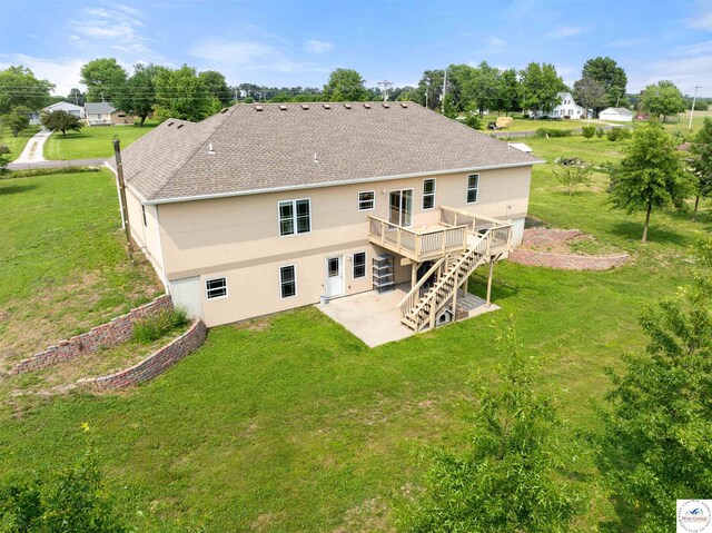 29854 Griessen Rd, Smithton, MO 65350 - back of house featuring a patio area, a shingled roof, a wooden deck, stairs, and a yard