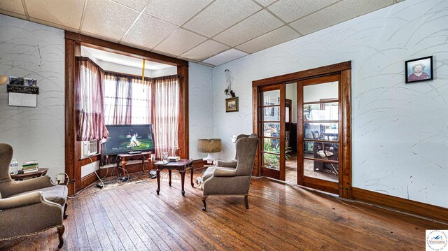 28302 S D State Rte, Cleveland, MO 64734 - living area featuring baseboards, hardwood / wood-style flooring, a textured wall, and a drop ceiling