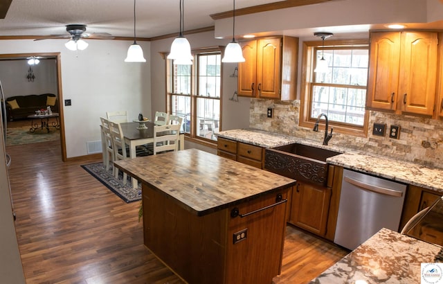 kitchen with wood counters, tasteful backsplash, stainless steel dishwasher, a sink, and dark wood-type flooring