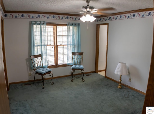 sitting room featuring a textured ceiling, carpet flooring, ceiling fan, baseboards, and ornamental molding