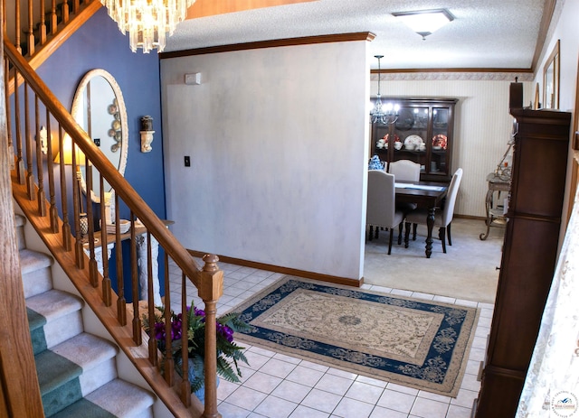 stairs featuring a textured ceiling, baseboards, an inviting chandelier, ornamental molding, and tile patterned flooring