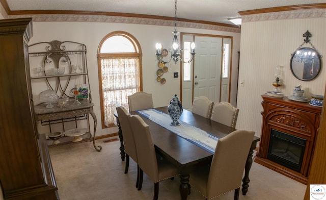 1679 Sunchase Dr, Warsaw, MO 65355 - dining area featuring baseboards, crown molding, light carpet, a notable chandelier, and a glass covered fireplace
