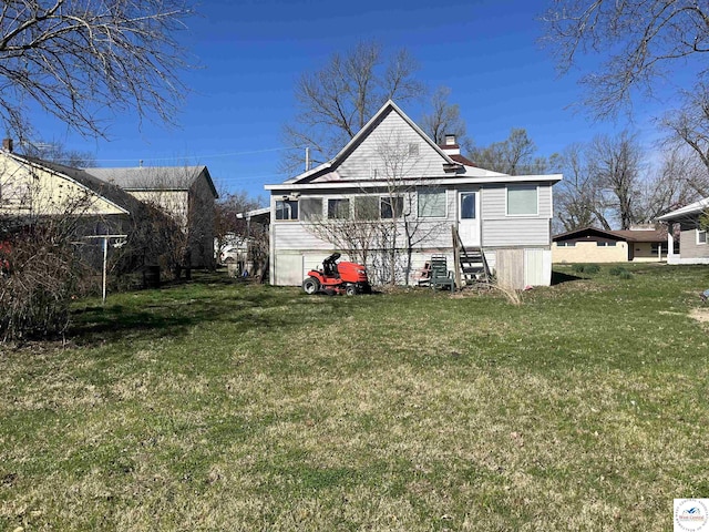 rear view of property featuring a chimney and a yard