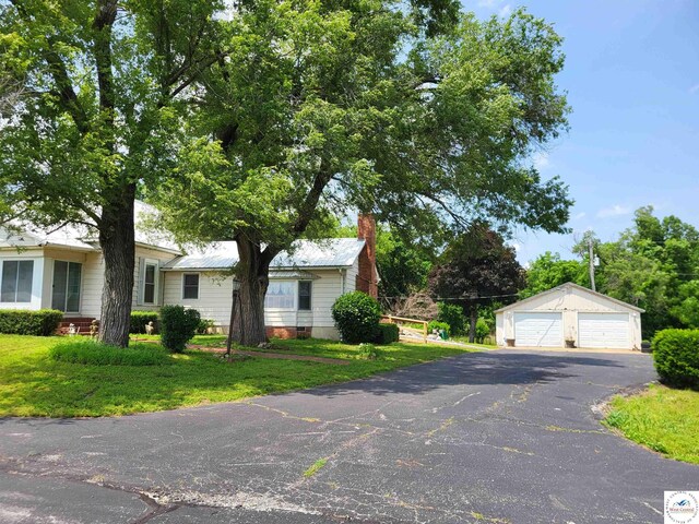 81 SE 500th Rd, Clinton, MO 64735 - view of front of home with a garage, an outdoor structure, a front yard, and a chimney