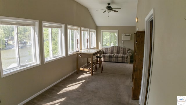 sunroom with carpet floors, baseboards, lofted ceiling, and a wall mounted AC