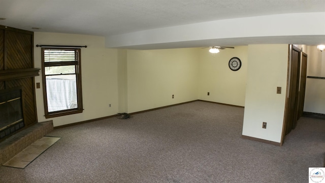 unfurnished living room featuring carpet flooring, baseboards, and a glass covered fireplace