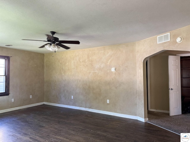 109 E Fairview St, Clinton, MO 64735 - unfurnished room featuring arched walkways, dark wood finished floors, a ceiling fan, and a textured ceiling