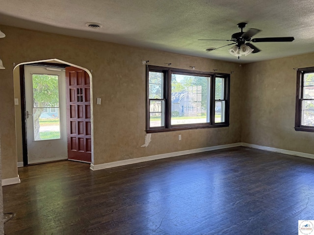 109 E Fairview St, Clinton, MO 64735 - unfurnished room with dark wood-type flooring, a ceiling fan, arched walkways, and a textured ceiling