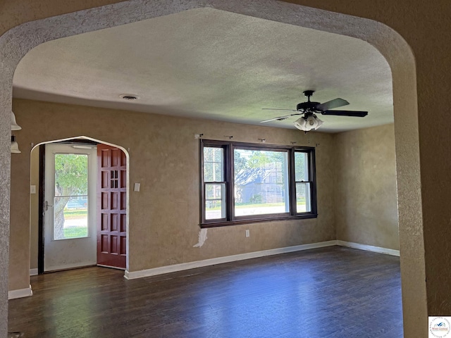 109 E Fairview St, Clinton, MO 64735 - spare room featuring dark wood finished floors, healthy amount of natural light, ceiling fan, a textured ceiling, and a textured wall