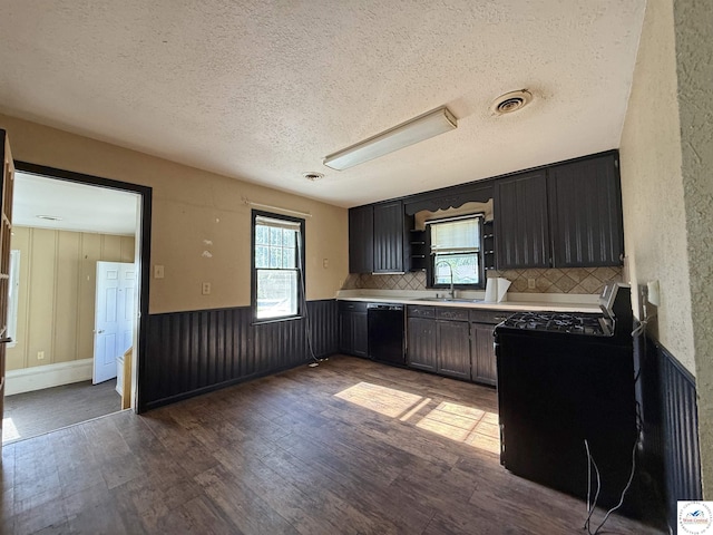 109 E Fairview St, Clinton, MO 64735 - kitchen featuring black appliances, dark wood-type flooring, a textured ceiling, light countertops, and decorative backsplash