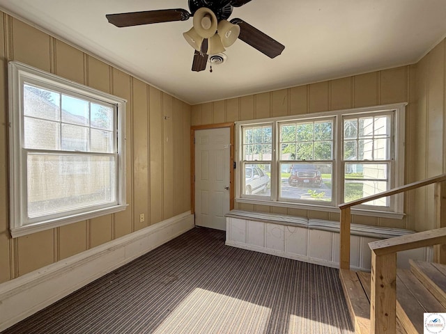 109 E Fairview St, Clinton, MO 64735 - carpeted spare room with healthy amount of natural light, a decorative wall, ceiling fan, and stairway